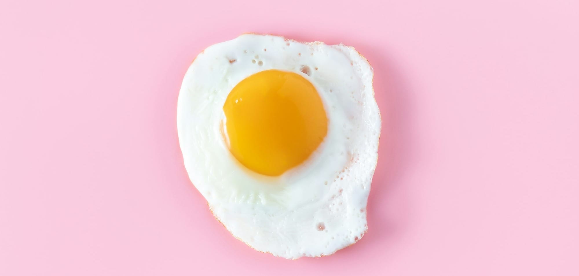 sunny side up egg on pink surface